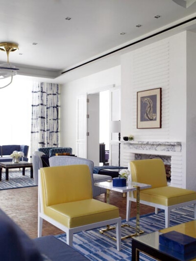 温暖的黄色皮椅为蓝白空间注入跃动活力，直角造型和金属支架案几皆是典型的现代风格。