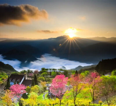 台湾东升镇日出，太阳穿过厚厚的云层升起，光芒照耀着风景秀美的小镇，让人仿佛置身童话世界。