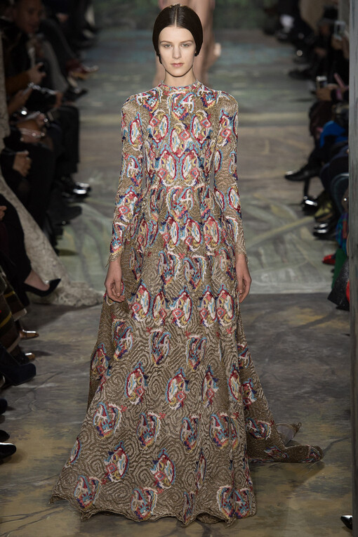 Valentino Spring2014Couture本季高级定制秀再一次选择向古典歌剧艺术致敬?？ook就将作曲家威尔第创作的《茶花女》一曲的五线谱刺绣在半透明的绢纱长裙上；普切尼的《波西米亚人》启发了他们创作出优雅的藏蓝色开士米斗篷和真丝紧身裙；比才的《卡门》衍生出银灰色蕾丝刺绣的古铜色褶皱礼服；法国作曲家Camille Saint-Sa?ns创作的歌剧《动物狂欢节》更是启发设计师让天鹅、雄狮、大象、猩猩、蛇等原始丛林的物种爬上了Valentino高定的奢华礼服之上，奏出原始狂野与优雅艺术的交响曲。