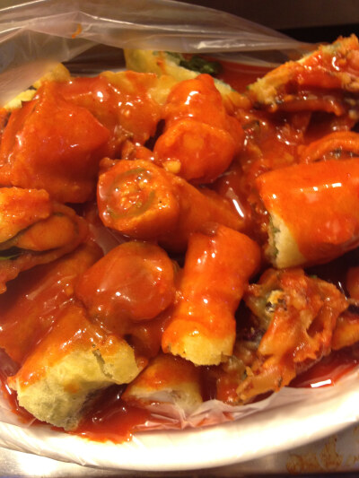 首尔路边摊卖的一种炸物，里面有蔬菜，有虾，重点是上面的辣酱汁吃起来很过瘾～