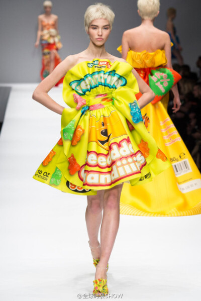 莫斯奇诺 (Moschino) 2014秋冬女装秀，设计师用巧克力和膨化食品包装袋做礼服，Jeremy Scott像过家家一样，把自己最朴实的坏品味都倒了出来，却叫人讨厌不起来，反而觉得自由自在不装腔也很有爱。