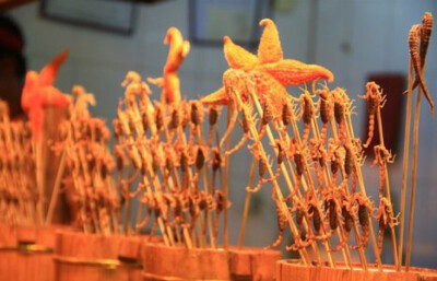 这是王府井小吃一条街出售的烤蝎子.很多蝎子还是活的哦.不过价钱太贵.25块一串～～～广州的菜市场五块钱可以买十只了。