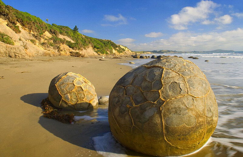 The Moeraki Boulders，这些不可思议的石块最早形成于新西兰的海底，经过百年侵蚀，如今他们则静静地坐落在这片广阔的沿岸沙滩上