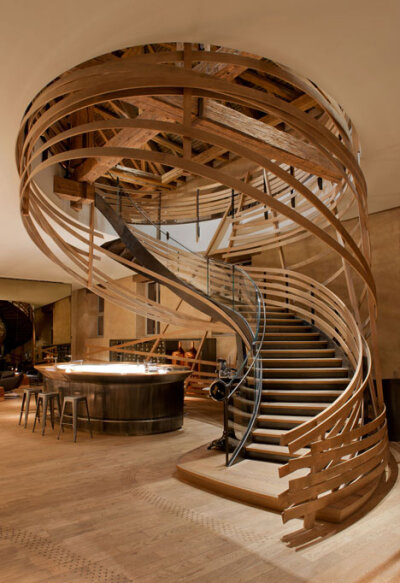 Wooden strips coil around staircase at Strasbourg hotel by Jouin Manku