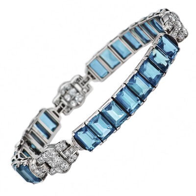 Oscar Heyman Brothers Aquamarine and Diamond Bracelet A stunning signed bracelet from Oscar Heyman Brothers, circa 1925, showcases 24 aquamarines, 25.00 carats, linked with diamond accents, 1.35 carat…