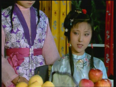 一身清爽的雪青色，衣袍上绣有竹、梅图案；下系雪白色纱裙，时已初夏，这是典型的夏装。发型和化装方面比平时多了几分轻灵，唇色尤为娇艳。手中所持的玉兰团扇更是为这一造型增色不少，清丽中透出了几分端庄。