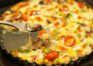 【土豆泥披萨】材料：土豆、培根、圣女果、洋葱、玉米粒、番茄酱、盐、黑胡椒碎、马苏里拉奶酪、胡萝卜粒、豌豆步骤：1.把原料准备好，玉米，豌豆和胡萝卜是，要提前焯水，培根要提前到微波炉里面烤熟或炒熟都可以2.土豆去皮切厚片，上锅蒸熟。3.把土豆压成泥，可以加适量的牛奶和食盐。4.把土豆泥放入烤盘里面，用勺子压实，倒入番茄酱，用刷子抹均匀。5.放入玉米、豌豆和胡萝卜粒，再放入圣女果片和洋葱条，把培根切小块放上面。放入马苏里拉奶酪，尽量撒均匀些，再放些玉米、豌豆、胡萝卜粒点缀，也可以撒些黑胡椒增加风味。6.最后挤入些番茄酱。7.烤箱预热180度，上下火，中层，25分钟左右即可。