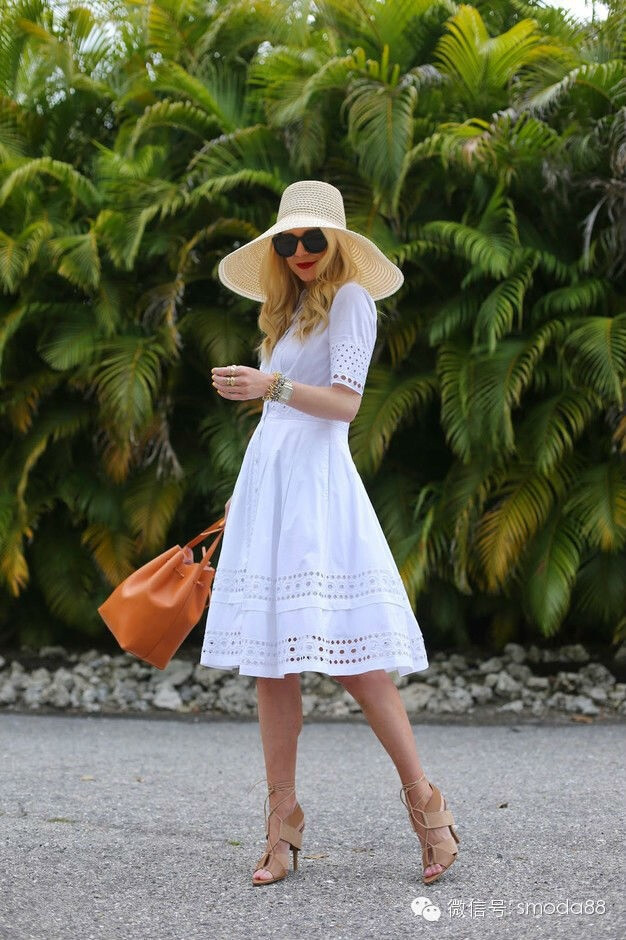 大叶片的绿植背景，白衣最搭。手脚动作生动，提包制造动感。