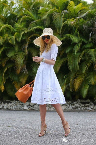 大叶片的绿植背景，白衣最搭。手脚动作生动，提包制造动感。