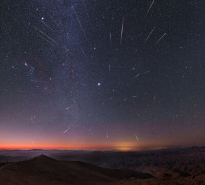 一年一度的双子座流星雨在12月13号和14号在地球上如雨点般降临。流星后面的天空中，木星显得格外耀眼，银河系中心带垂直显示于图片左边，而粉红色的猎户座大星云则位于更左侧。
