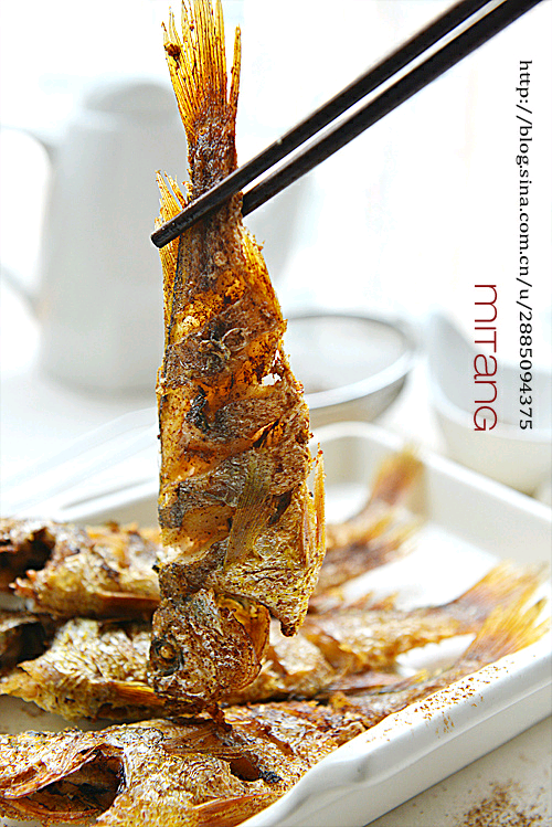 酥炸五香黄花鱼 材料:小黄花8条、生抽2勺、盐1小勺、料酒1勺、胡椒粉适量、葱姜片适量、五香粉适量 1、将小黄花的鳃部翻开,将中间相连的部分剪一下。从鳃部用筷子伸到肚子里绕几下,将鳃揪掉,连鱼肠一块儿拽出,将鱼肚子的脏物清理干净即可 2、去除鱼鳞,鱼身剞一字花刀,加入生抽、料酒、盐、胡椒粉和葱姜片腌渍半小时。腌好的小黄花吸净水分备用 3、锅中加油烧至7成热,放入鱼炸制,至定型硬挺捞出,然后复炸一遍至金黄色 4、捞出沥油,用吸油纸吸掉多余油脂,趁热均匀筛上适量五香粉即可