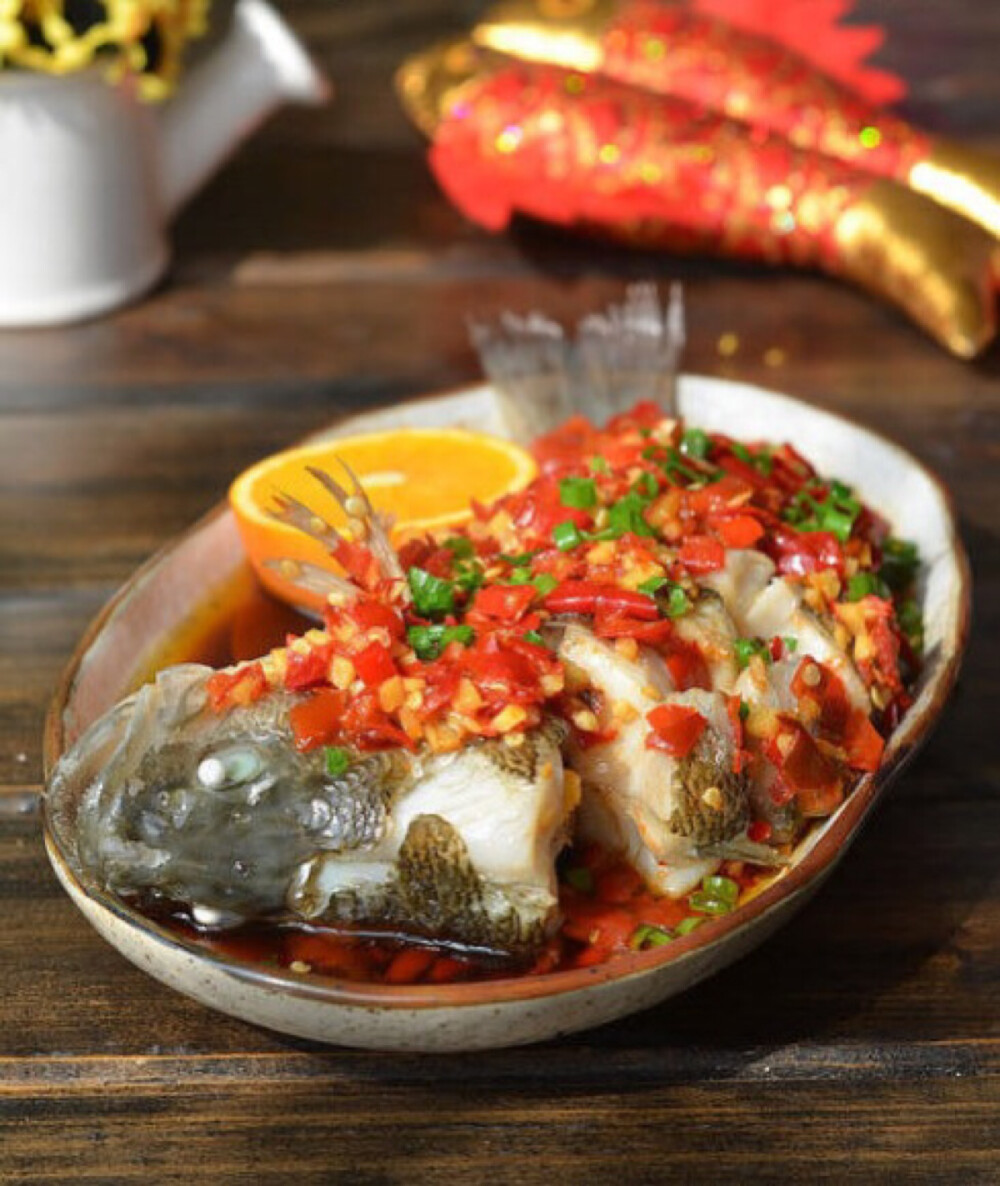 (剁椒鲈鱼)材料:新鲜鲈鱼一条(约500克),剁椒,姜,葱,油,盐,料酒,蒸鱼