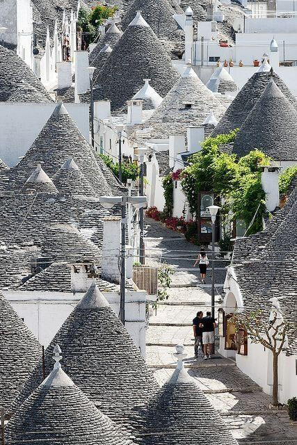 Trulli in Alberobello, Bari, Puglia, Italy。阿尔贝罗贝洛是意大利普利亚大区巴里省的一个小城，城内圆锥形房顶的特鲁洛建筑(trullo,复数为trulli)世界知名，1996年被联合国教科文组织列为世界文化遗产。特鲁洛的特色是墙壁用石灰涂成白色，屋顶则用灰色的扁平石块堆成圆锥形。据说是当地人为了逃税而造，收税时就把屋顶拆掉，表示这里没有人居住。