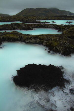 Blue Lagoon in Grindavík, Iceland。冰岛格林达维克蓝色礁湖，拥有全球最大火山区，频繁的火山和地壳活动，创造了无数的湖泊、温泉及瀑布，地热和水力成为唾手可得的能源。蓝色礁湖是全世界最大的露天温泉，冰岛全年气温都很冷，就算是夏天，气温仍徘徊在摄氏十度左右，而蓝色礁湖的泉水抽取自两千米的地底，长年维持在摄氏三十七度左右。