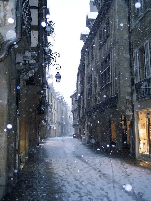 Snow falling on the Rue Verrerie, Dijon, France。法国第戎的玻璃艺术街。第戎作为勃艮第省的首府，不但是个满载文化遗产的艺术城、一个世界闻名的美食镇、一个商业中心，而且还是通往勃艮第葡萄酒产区，前往探索其中小镇风光与葡萄美酒的起点。第戎是芥末的原产地，同时是一个以蜗牛菜等美食闻名的城市。玻璃艺术街，这条位于老商业区的用鹅卵石铺就的街道上排列着中世纪的半木结构房屋。有一些房屋，如第8、10、12号还有精美的木刻。