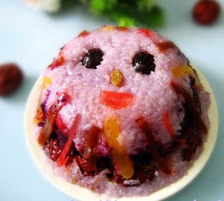 紫薯八宝饭的做法 主料： 紫薯 1个 糯米 两杯 橄榄油 适量 辅料： 葡萄干 蜜枣 糖玫瑰 杏脯 红枣 蜜制薯干 京糕 枸杞 各一小份 调料： 砂糖或蜂蜜 适量 1 糯米淘净浸泡一小时; 2 紫薯蒸熟或煮熟后捣成泥，加入蜂蜜或糖水调匀; 3 蜜饯洗净切丝切块备用; 4 糯米与水1：1.5的比例煮熟，煮之前在水里放一勺紫薯泥，将这一勺薯泥在水中搅化，使紫色均匀的融在煮米水中; 5 取一个碗，碗内抹橄榄油，按照喜欢的图案开始摆放蜜饯和糯米。通常第一层要放蜜饯比较好看，第二层是糯米，第三层再放蜜饯，第四层糯米，第五层放拌好的紫薯泥，也可以放豆沙，第六层糯米。6 最后放至同碗口齐平，在表面铺一层保鲜