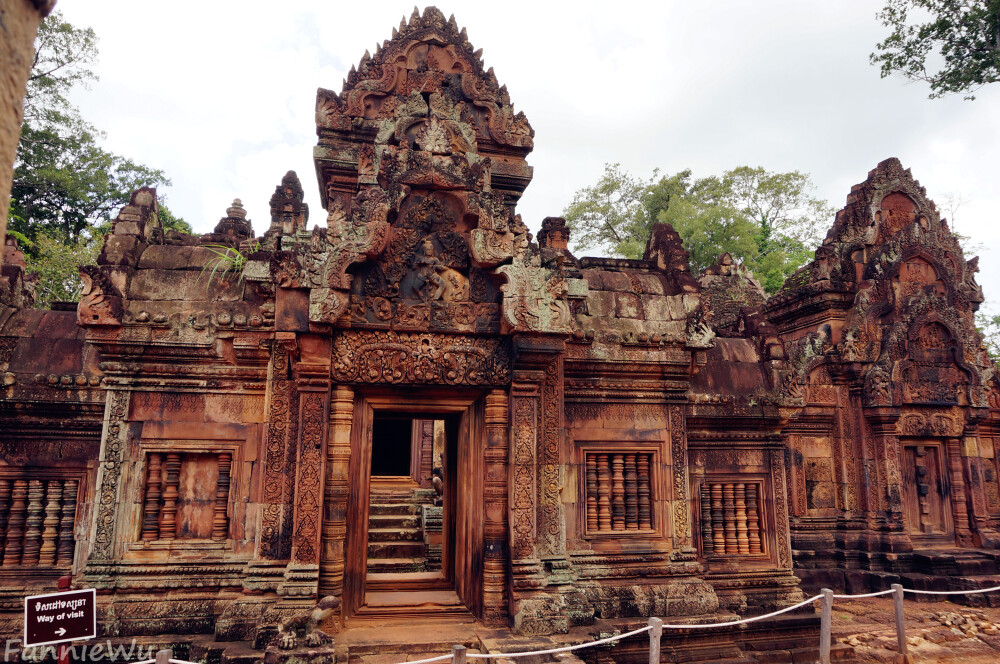 Banteay Srei,Siem Reap,Cambodia。（Photo by Fannie Wu）女王宫被誉为吴哥艺术皇冠上的一颗珍珠。与大部分吴哥古迹所使用的青砂岩不同，女王宫采用高棉特有的红土和略带桃色的石块建造，色彩极为艳丽。内有世界上最好的石雕作品，它是吴哥比较小的一处景点，虽然规模不大，但却声名显赫，是吴哥古迹中风格最独特和最精致的建筑群之一。