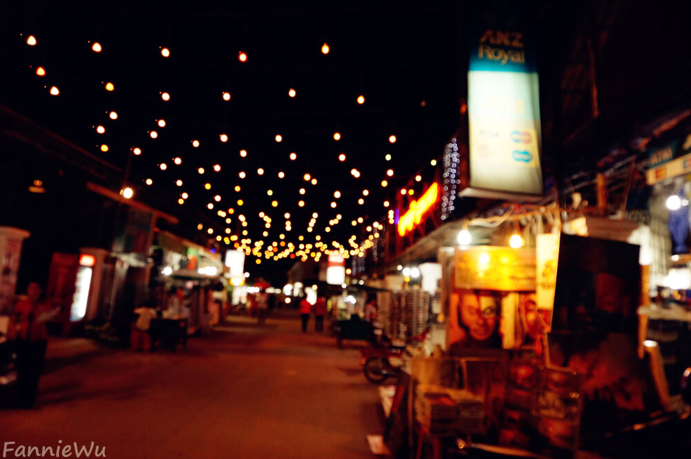 Angkor Night Market,Siem Reap,Cambodia。（Photo by Fannie Wu）吴哥夜市就位于暹粒市区最繁华的地段，紧邻老市场和酒吧街。相比老市场，吴哥夜市要整洁一些。每到晚上，这里便成为各国游客最喜欢的消遣地之一，热闹非凡。