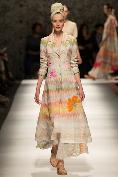 Missoni Collezioni Primavera Estate 2015。米索尼2015春夏米兰时装周女装以“艳阳之夏”为主题。巧妙运用色阶，表现一天中的光线变化；廓形一张一弛，展现顾盼生姿的隽逸。让人联想到一个时髦的年轻女郎，半躺在游…