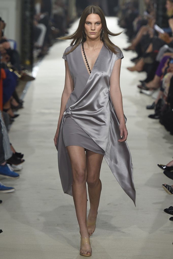 Alexis Mabille RTW Spring 2015。艾历克西斯·马毕2015巴黎时装周春夏高级成衣发布以一件拳击手外套式的改良裙装开场，奠定了这一季运动风的基调。与以往强调女性曲线的设计略有不同，这一季设计师让服装变得更轻松随意。笔挺的线条和拉链被改为不对称、松紧，舒适也许是这一季设计的核心。