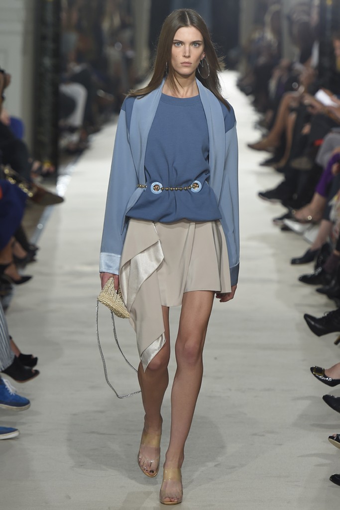 Alexis Mabille RTW Spring 2015。艾历克西斯·马毕2015巴黎时装周春夏高级成衣发布以一件拳击手外套式的改良裙装开场，奠定了这一季运动风的基调。与以往强调女性曲线的设计略有不同，这一季设计师让服装变得更轻松随意。笔挺的线条和拉链被改为不对称、松紧，舒适也许是这一季设计的核心。
