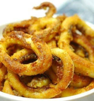 【咖喱鱿鱼圈】1.鱿鱼洗净部分切圈儿,鱿鱼须冷藏;2.1大匙咖喱粉.2大匙面粉和适量的盐在塑料袋里混匀,放入切好的鱿鱼圈,晃动使鱿鱼圈儿沾满混好的粉类;3.锅热油,转中火,放入沾满粉的鱿鱼圈来煎,煎好一面后,再煎另一面;4.两面都煎好后,出锅装盘即可。