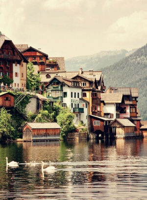 Hallstatt,Austria。哈尔施塔特镇是奥地利上奥地利州萨尔茨卡默古特地区的一个村庄， 位于哈尔施塔特湖湖畔。历史上这一地区就因盐而致富。因此这里又被称作“世界最古老的盐都”。 哈尔施塔镇也被称为世界上最美的小镇， 来到这里，发现这里有一种安静恬然的气韵， 是一种纯正淡定的欧洲气质， 到处能看见童话般清幽美丽的小木屋， 纯净的生命气息散发在空气中。恬淡，美好。哈尔施塔特的居民更喜欢把自己的家乡称作“木头镇”。