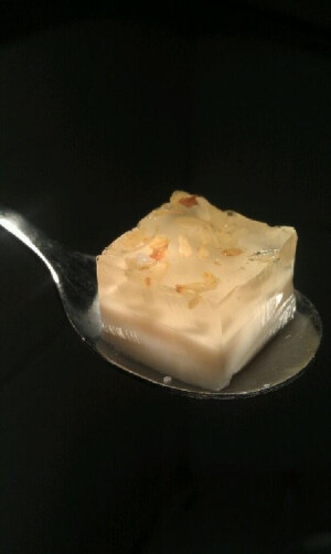 牛奶桂花冻 做法： 1.先来做【桂花冻层】 首先用150克饮用水泡软两片吉利丁 2.将水和泡软的吉利丁倒进煮锅里，加进10克白砂糖，小火加热至砂糖和吉利丁都融化 3.撇去糖水上的浮沫，加入糖桂花搅拌均匀 4.将糖水倒进模具，至模具一半深的位置即可 5.将模具放进冰箱冷藏至桂花冻凝固。 6.桂花冻凝固以后，再来做【牛奶冻层】 用150克牛奶泡软剩下的两片吉利丁 7.将牛奶和泡软的吉利丁放进煮锅，加入10克白砂糖，小火加热至吉利丁和糖都融化 8.将奶液放凉，取出已经其中桂花层已凝固的模具，将奶液倒在桂花层上。