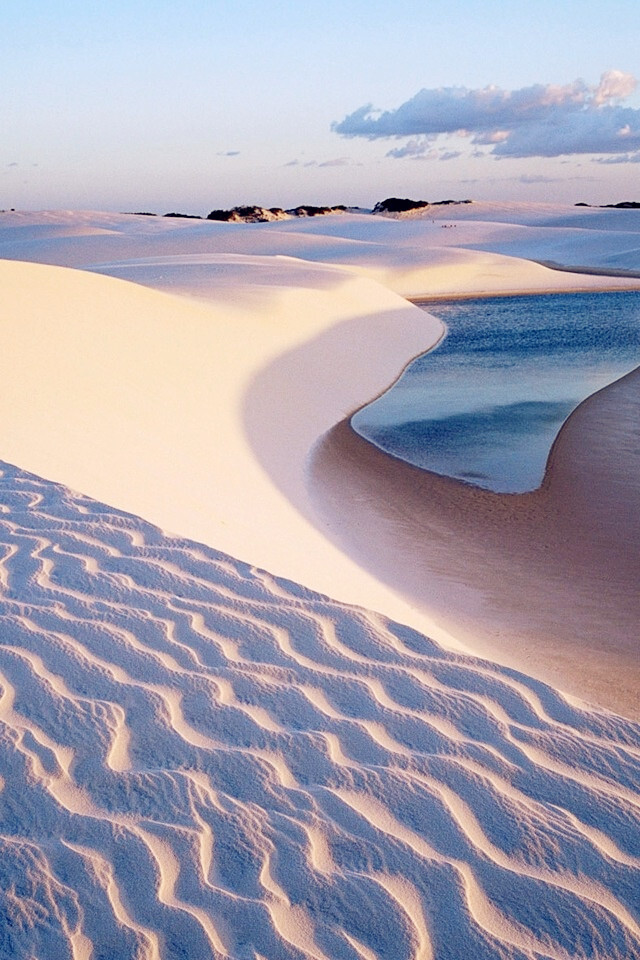 This Lençóis Maranhenses National Park, Brazil。巴西伦索伊斯国家公园。巴西伦索伊斯·马拉赫塞斯国家公园，位于巴西北部海岸。公园内的白色沙丘（有的有些时候能高达40米高）之间点缀着水晶般蔚蓝的礁湖，在一片完全像沙漠的景象中形成了一个个的热带园地。湖水有三米深，维持在三十摄氏度，一年中的很多时候都可以在这游泳。该公园看起来像是一个巨大的自然水上公园。