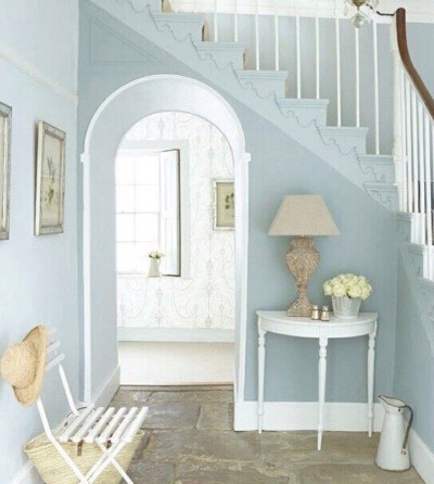 美美的粉蓝色楼梯下玄关，一把白色的椅子，一张半圆形的白色桌子，精致的台灯，淡雅的插花，打造出休闲而梦幻的角落，犹如童话中公主般的城堡般唯美。