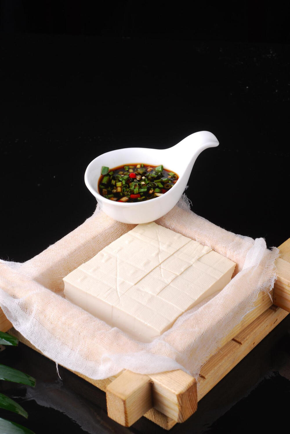 推豆腐，是湘西过年时，家家户户都得完成的任务。 选上好的黄豆，洗净，浸泡，泡得软软的，再一勺勺喂给磨子，磨子一口一口地嚼成泥磨成浆。白中带黄的黄豆浆放在纱布过滤，将豆渣过滤出。过滤出的豆渣，一般人会把 豆渣立刻处理掉。湘西人吃了一餐新鲜的豆渣后，会把豆渣捏成一个个团子，装进一个篮子，跟腊肉一起熏。十天半月后，熏过的豆渣干干的、黄黄的、硬硬的，一股浓香，跟大 蒜、白菜之类的炒吃，更香，那香浓得一个寨子都听得到。过滤后的豆浆，用开水煮熟，冷却，点浆。点浆就是放石膏粉，不能多，也不能少，多了，会豆腐很少，味道很差；少 了，就会全是网眼，捻不起来。点了浆，就成了豆腐脑。把豆腐脑舀进纱布