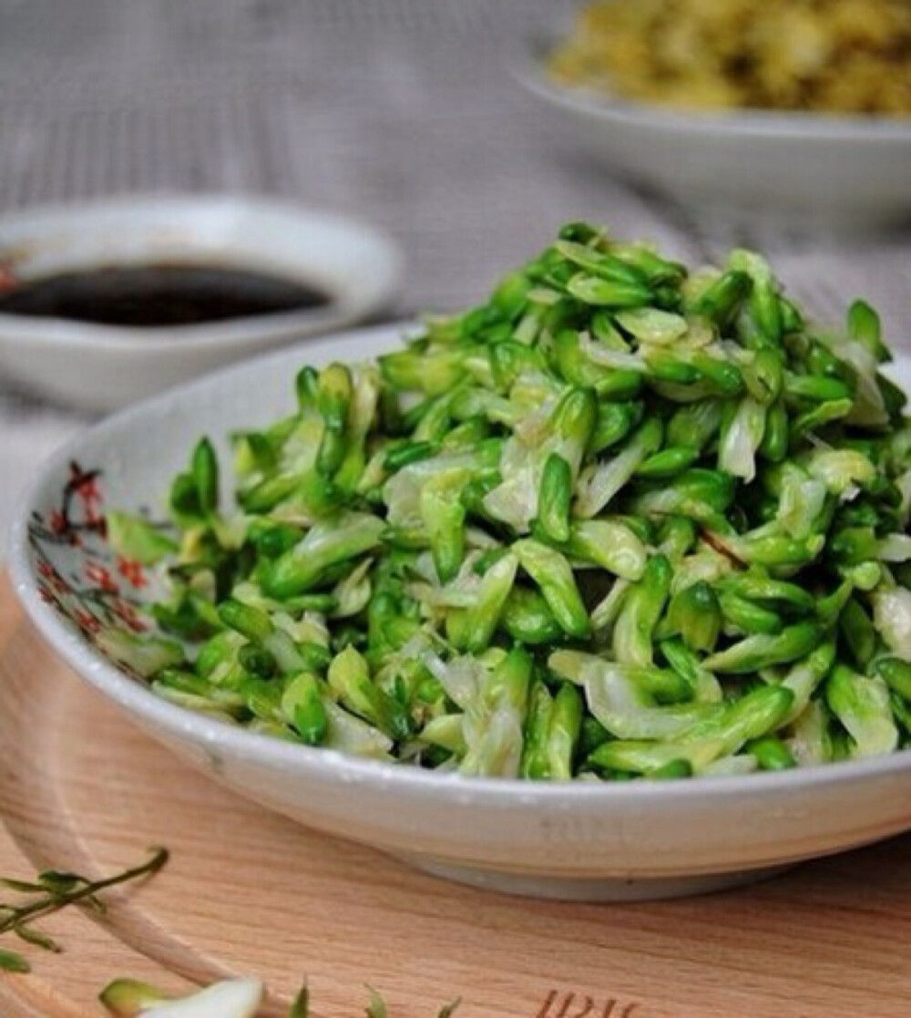 【凉拌槐花】槐花拣净叶片和叶梗,清洗干净;入开水中焯一下,捞出过凉