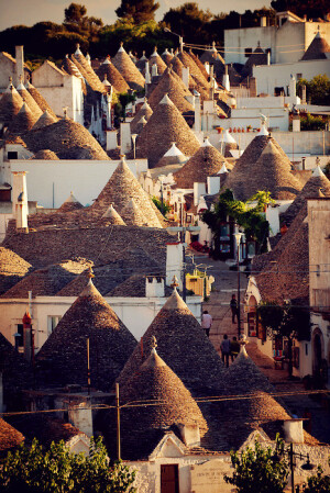 Alberobello, Bari, Puglia, Italy。阿尔贝罗贝洛是意大利普利亚大区巴里省的一个小城，城内圆锥形房顶的特鲁洛建筑(trullo,复数为trulli)世界知名，1996年被联合国教科文组织列为世界文化遗产。特鲁洛的特色是墙壁用石灰涂成白色，屋顶则用灰色的扁平石块堆成圆锥形。据说是当地人为了逃税而造，收税时就把屋顶拆掉，表示这里没有人居住。