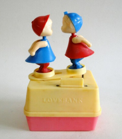 小时候用的那种储钱罐，两个小孩可以kiss，前面凸起的小方块可以投币，也可以滑动，具体怎么弄我给忘了，小时候我也有一个，不过搬家的时候弄丢了...