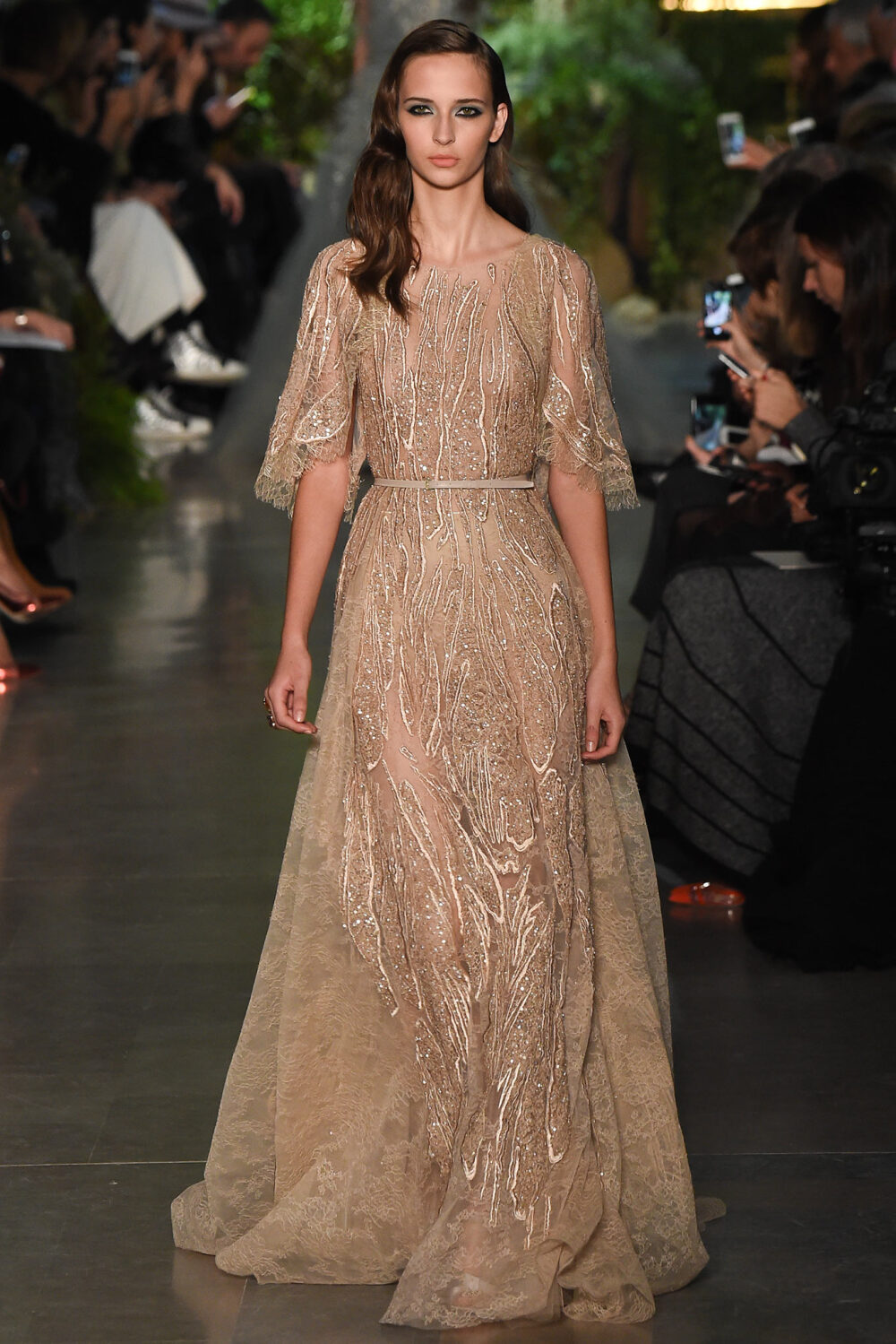 Elie Saab Spring 2015 Couture。艾莉·萨博2015春夏巴黎高级定制时装周在一片片绿色植被花丛中拉开帷幕。本季，以“忧伤的挽歌”向家乡贝鲁特致敬，Elie Saab以“花”为主题，重笔墨于轻盈的流苏与立体花朵装饰之上，结合他对美的深刻理解，用亮片刺绣点缀于薄纱中，轻绢曼纱、珠罗蕾丝，宛若花仙精灵，美得令人窒息。