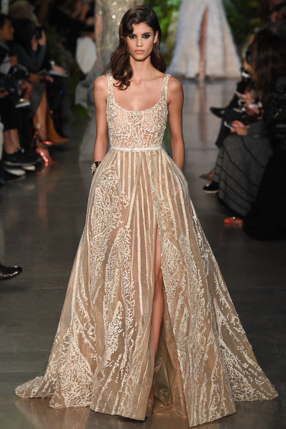 Elie Saab Spring 2015 Couture。艾莉·萨博2015春夏巴黎高级定制时装周在一片片绿色植被花丛中拉开帷幕。本季，以“忧伤的挽歌”向家乡贝鲁特致敬，Elie Saab以“花”为主题，重笔墨于轻盈的流苏与立体花朵装饰之上，结合他对美的深刻理解，用亮片刺绣点缀于薄纱中，轻绢曼纱、珠罗蕾丝，宛若花仙精灵，美得令人窒息。