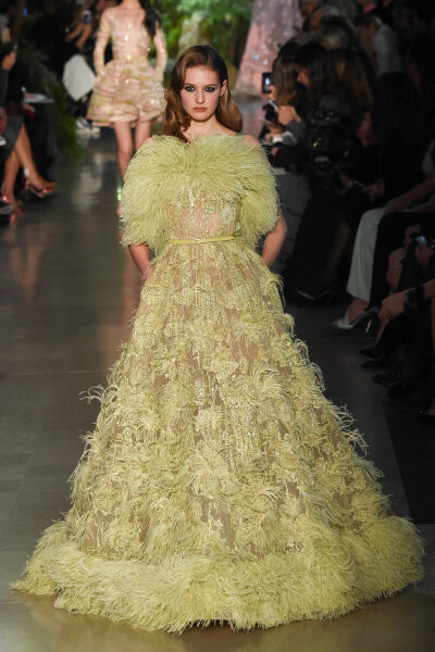 Elie Saab Spring 2015 Couture。艾莉·萨博2015春夏巴黎高级定制时装周在一片片绿色植被花丛中拉开帷幕。本季，以“忧伤的挽歌”向家乡贝鲁特致敬，Elie Saab以“花”为主题，重笔墨于轻盈的流苏与立体花朵装饰之上…