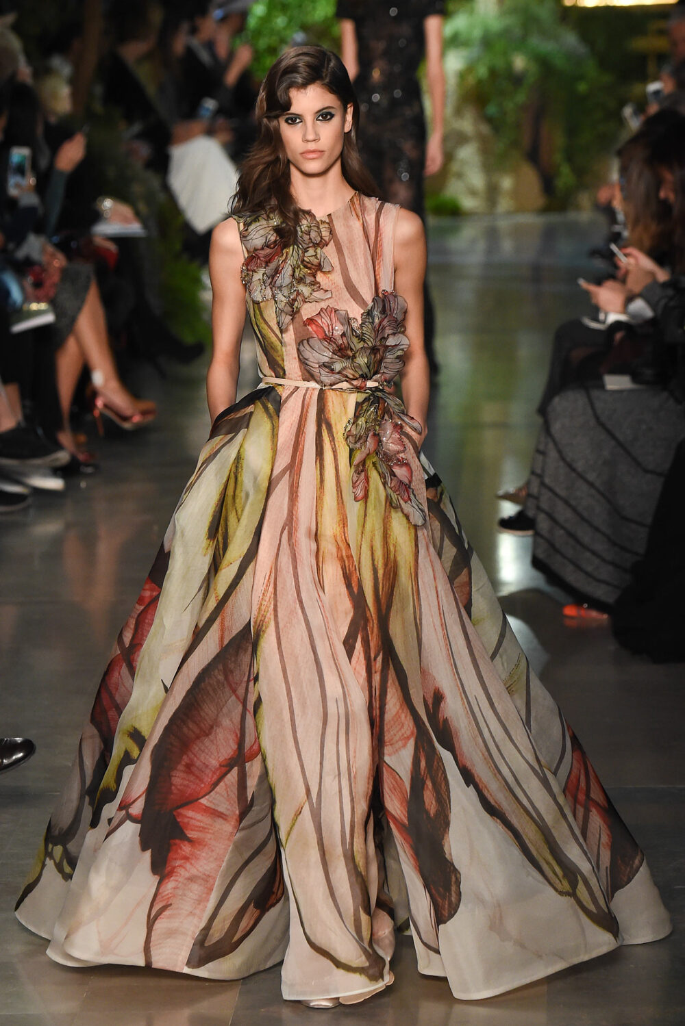 Elie Saab Spring 2015 Couture。艾莉·萨博2015春夏巴黎高级定制时装周在一片片绿色植被花丛中拉开帷幕。本季，以“忧伤的挽歌”向家乡贝鲁特致敬，Elie Saab以“花”为主题，重笔墨于轻盈的流苏与立体花朵装饰之上，结合他对美的深刻理解，用亮片刺绣点缀于薄纱中，轻绢曼纱、珠罗蕾丝，宛若花仙精灵，美得令人窒息。