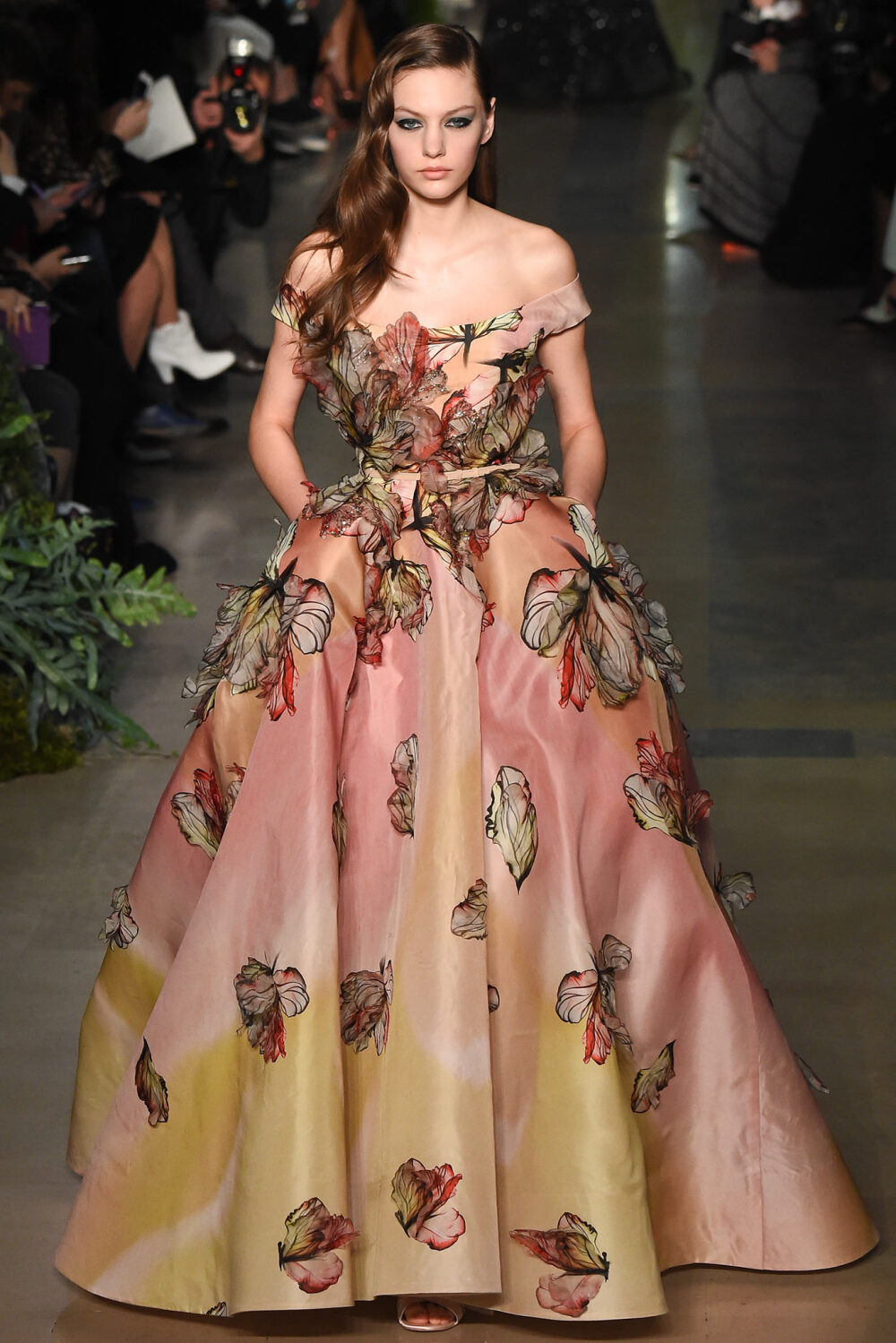 Elie Saab Spring 2015 Couture。艾莉·萨博2015春夏巴黎高级定制时装周在一片片绿色植被花丛中拉开帷幕。本季，以“忧伤的挽歌”向家乡贝鲁特致敬，Elie Saab以“花”为主题，重笔墨于轻盈的流苏与立体花朵装饰之上，结合他对美的深刻理解，用亮片刺绣点缀于薄纱中，轻绢曼纱、珠罗蕾丝，宛若花仙精灵，美得令人窒息。