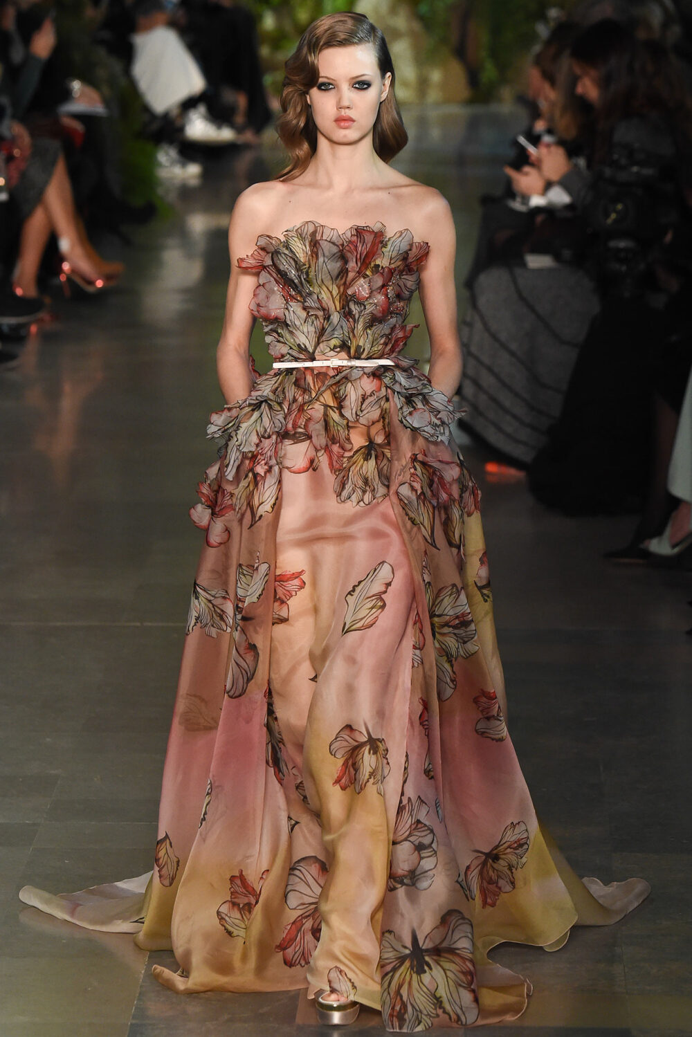 Elie Saab Spring 2015 Couture。艾莉·萨博2015春夏巴黎高级定制时装周在一片片绿色植被花丛中拉开帷幕。本季，以“忧伤的挽歌”向家乡贝鲁特致敬，Elie Saab以“花”为主题，重笔墨于轻盈的流苏与立体花朵装饰之上，结合他对美的深刻理解，用亮片刺绣点缀于薄纱中，轻绢曼纱、珠罗蕾丝，宛若花仙精灵，美得令人窒息。