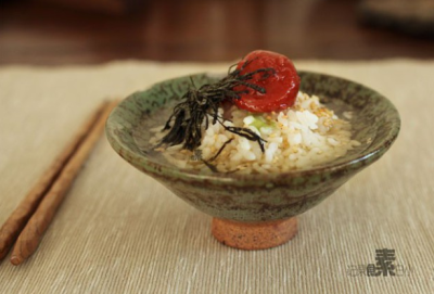 梅子茶泡饭的做法： 将米饭盛到碗中，撒上盐、酱油、熟芝麻、海苔丝最后摆上梅子。用烫烫的水沏茶，倒入碗中，没过米饭2/3处即可。