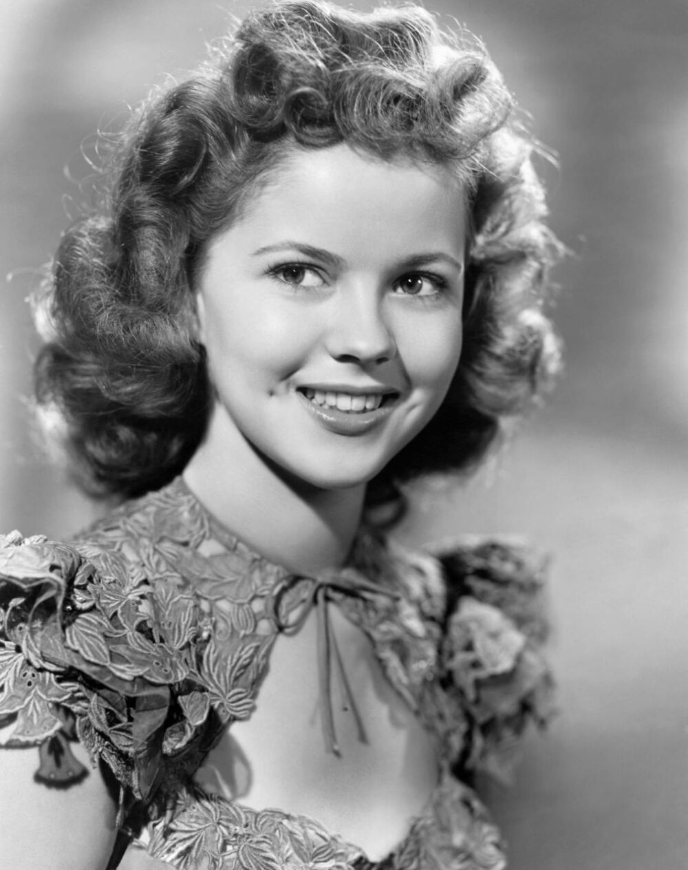 Shirley Temple 秀兰·邓波尔 （1928 — 2014） 明亮的眼睛、张开的滚圆手臂让每个人着迷；甩动的满头卷发为人们带来欢乐。1935 年至1938 年期间，Shirley Temple 成为全美国票房号召力最高的电影明星，将战后的20 世纪福斯电影公司从破产危机中拯救出来。年仅7 岁就获得了第7 届奥斯卡特别金像奖，在12 岁之前，她已经出演了超过40 部电影了。1950 年，她完全退出影坛，这个时机选得恰到好处。她不能再饰演天真无邪的角色，而全世界依然希望如此。