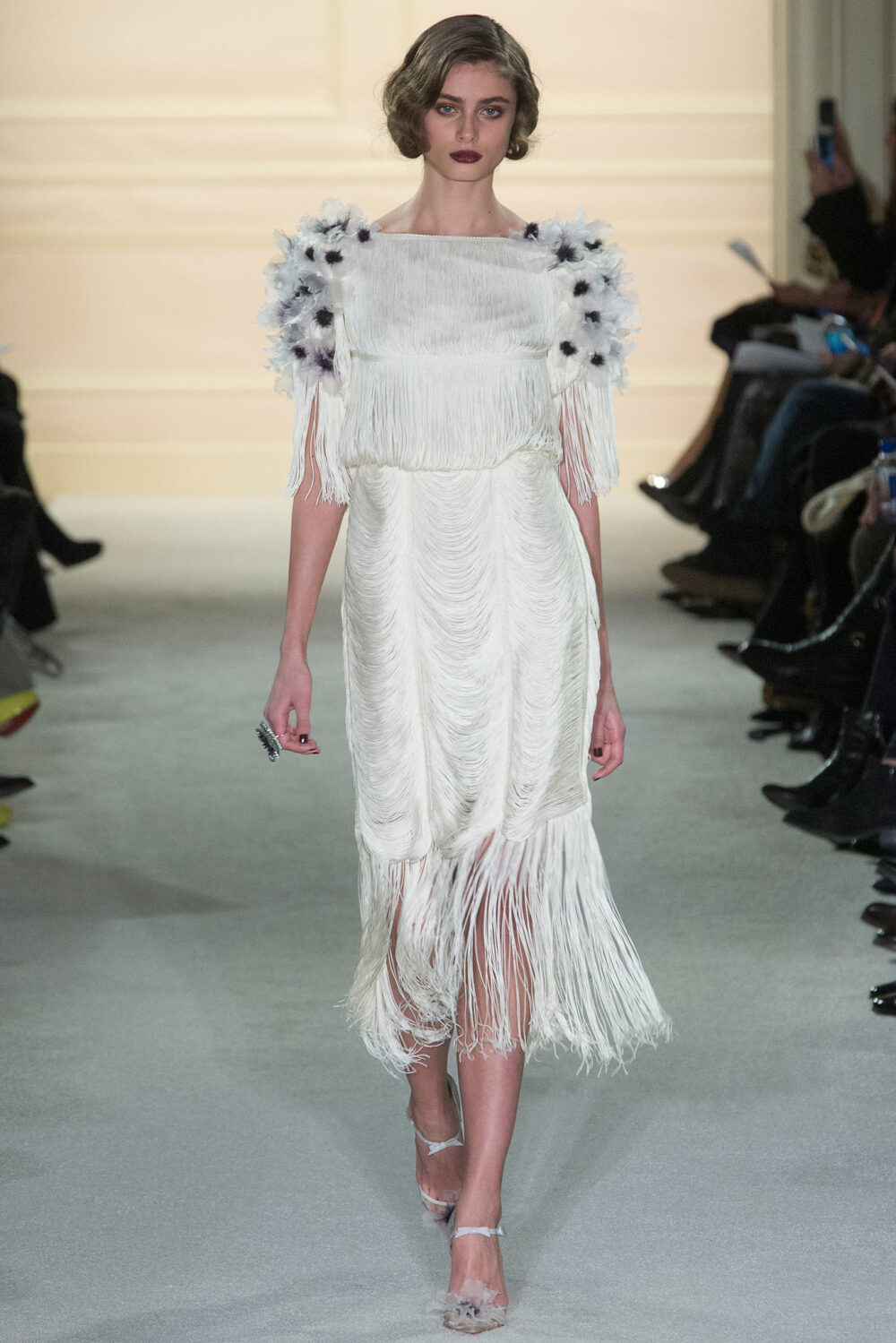 Marchesa Fall 2015 Ready-to-Wear。玛切萨2015纽约时装周秋冬女装秀华丽大胆、恣意风情，像20年代巴黎的名贵水粉，也像美国“爵士时代”漫天的纸醉金迷；像戏梦人生的巴黎交际花，也像菲茨杰拉德笔下的“盖茨比”女郎——如真也似幻。流苏的裙摆窸窣摆动起来，裸露的肌肤闪亮起来，周身的羽毛飞舞起来，媚态饱满的眉眼斜乜起来。Flapper女郎们又仙又接地气儿，明天再说明天的！狐步舞立刻跳将起来——欲望，你好；沉闷，再见！