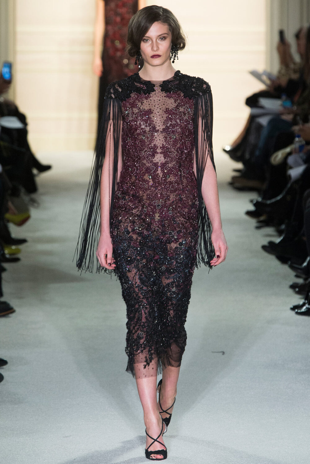 Marchesa Fall 2015 Ready-to-Wear。玛切萨2015纽约时装周秋冬女装秀华丽大胆、恣意风情，像20年代巴黎的名贵水粉，也像美国“爵士时代”漫天的纸醉金迷；像戏梦人生的巴黎交际花，也像菲茨杰拉德笔下的“盖茨比”女郎——如真也似幻。流苏的裙摆窸窣摆动起来，裸露的肌肤闪亮起来，周身的羽毛飞舞起来，媚态饱满的眉眼斜乜起来。Flapper女郎们又仙又接地气儿，明天再说明天的！狐步舞立刻跳将起来——欲望，你好；沉闷，再见！