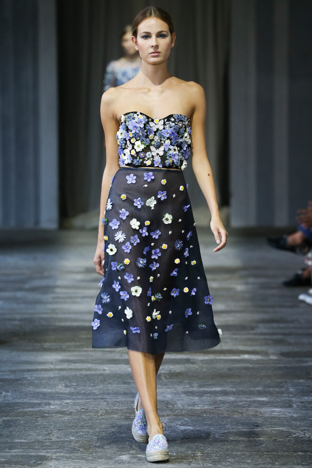 Luisa Beccaria Spring 2015 Ready-to-Wear。路易莎·贝卡里亚2015米兰时装周春夏高级成衣发布。在鲜向公众开放的圣辛普立西阿诺修道院，其漂亮的院子中举办的一场展示兼时装秀，向其出身名门的米兰朋友打招呼。身穿如舒芙蕾一样精致的连衣裙的模特们分散在静谧的花园中一道修道院的拱廊下，周围是喷泉的滴滴答答以及唱片上直抵灵魂的音乐在流淌。这营造了一种唤起前尘往事的背景气氛，非常适合展示这种已经得到认可的属于豪华婚礼和高门槛的元媛舞会中的完美风格。