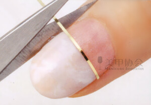 4、因为要贴带背胶的金属下，所以我们先要擦去表面浮胶，然后如图，在交界线出贴上金色线条。