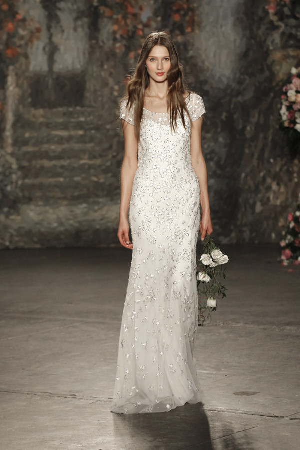 Jenny Packham Spring 2016 Bridal Collection。珍妮·帕克汉2016纽约婚纱时装周春夏发布。设计灵感来自莎士比亚的喜剧作品《仲夏夜之梦》，设计师将文学作品中的故事带入了现实之中，为新娘们打造了浪漫的嫁衣：欧根纱的花朵、水晶打造的植物叶子、珍珠刺绣与羽毛。设计师充分使用了春夏的绿色草地的色彩，飘逸的裙摆与紧身的胸衣打造了属于新娘们的浪漫世界。花朵蕾丝、刺绣与轻盈的雪纺面料以及施华洛世奇的水晶在灯光下闪耀着光芒，共同营造了属于春夏婚礼上的美丽梦境。