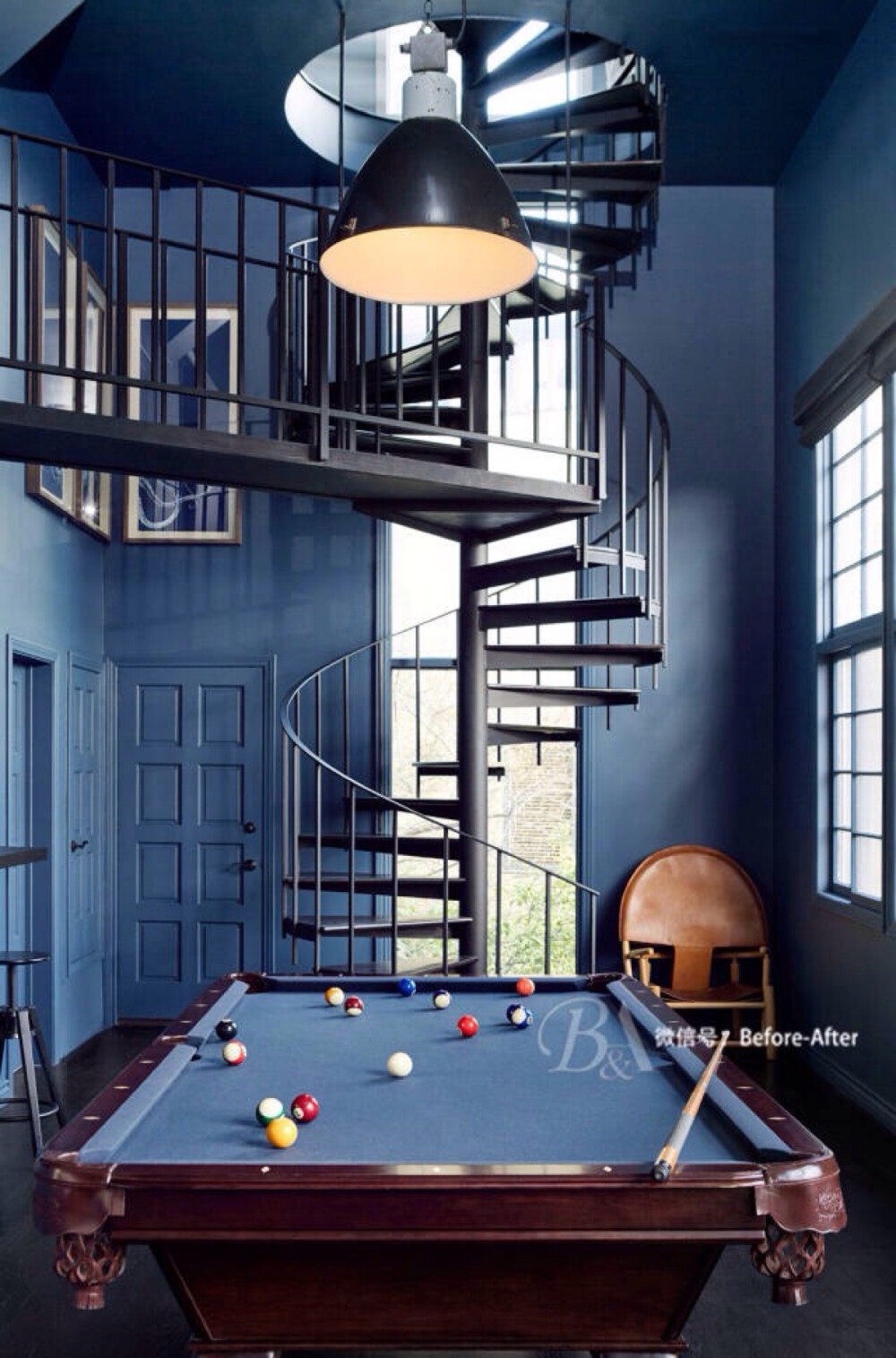 当从上至下的黑色铁艺楼梯贯穿整个空间，蓝色的墙面就像一个幕布，整个空间就像电影场景那般，留给人的是经典与不凡格调。