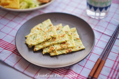 黄瓜软饼（黄瓜咸食） ｛做法：①鸡蛋打入面粉，加适量水搅拌成稀糊 ②黄瓜擦丝，姜切末放入面糊并加盐 ③平底铁锅放少于油烧热，摊入面糊铺整均匀 ④待面糊凝固定型，翻面 ⑤熟透出锅，切角方便食用｝