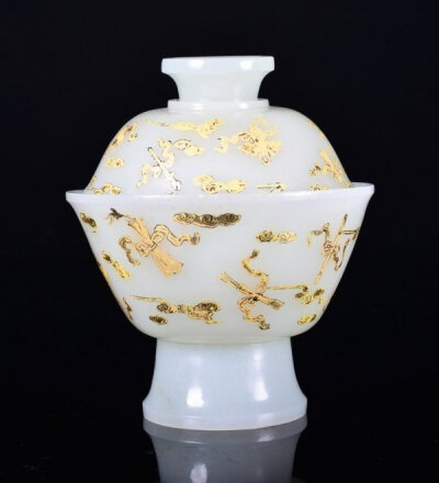 茶碗和茶盖呈盆地形状。茶碗外部装饰有弯曲的如意祥云。杯底有汉字封印。茶杯和茶盖都为白玉色。高约11.2厘米，清代。